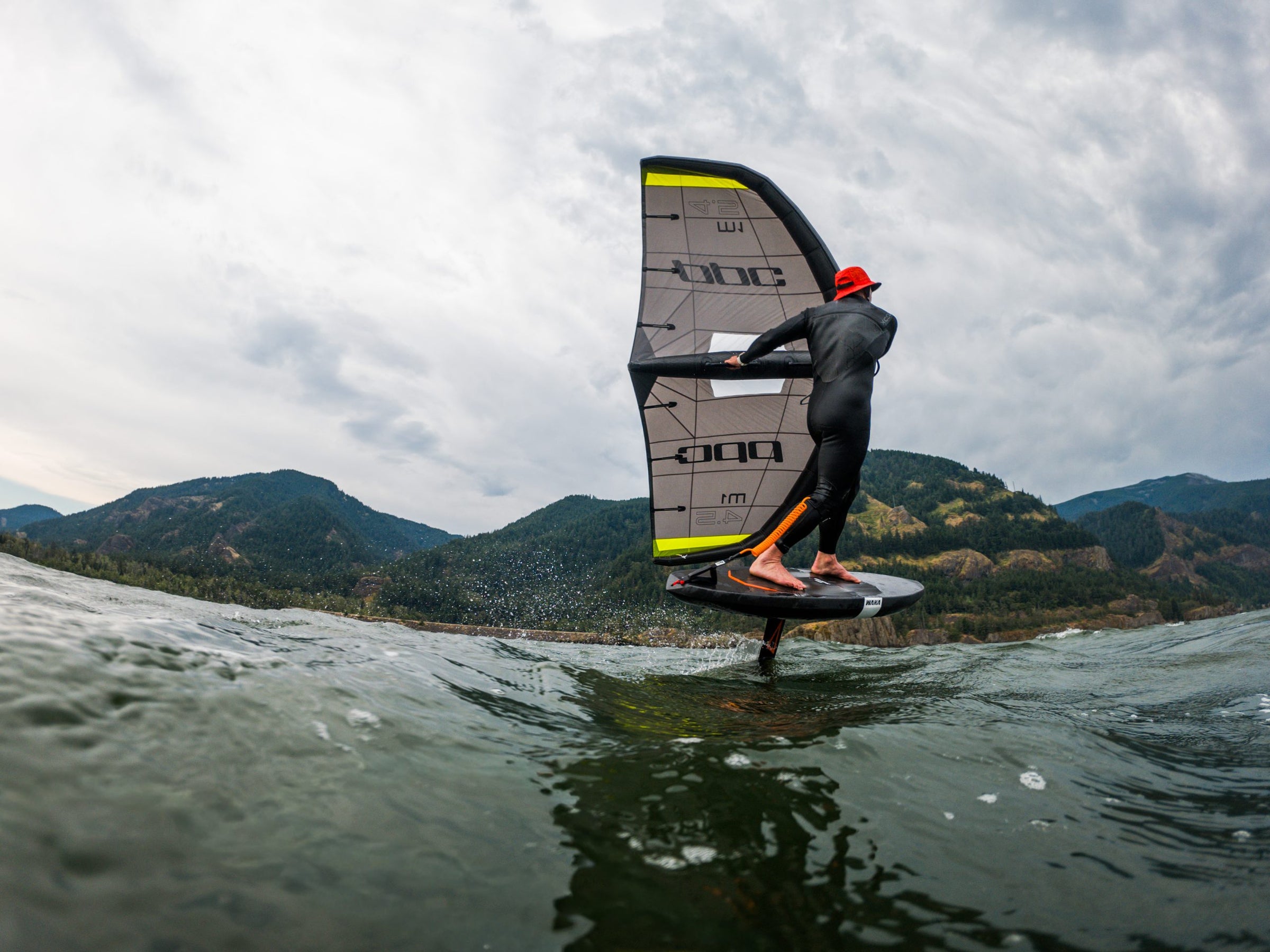 Wing foiling at water level, shot from behind