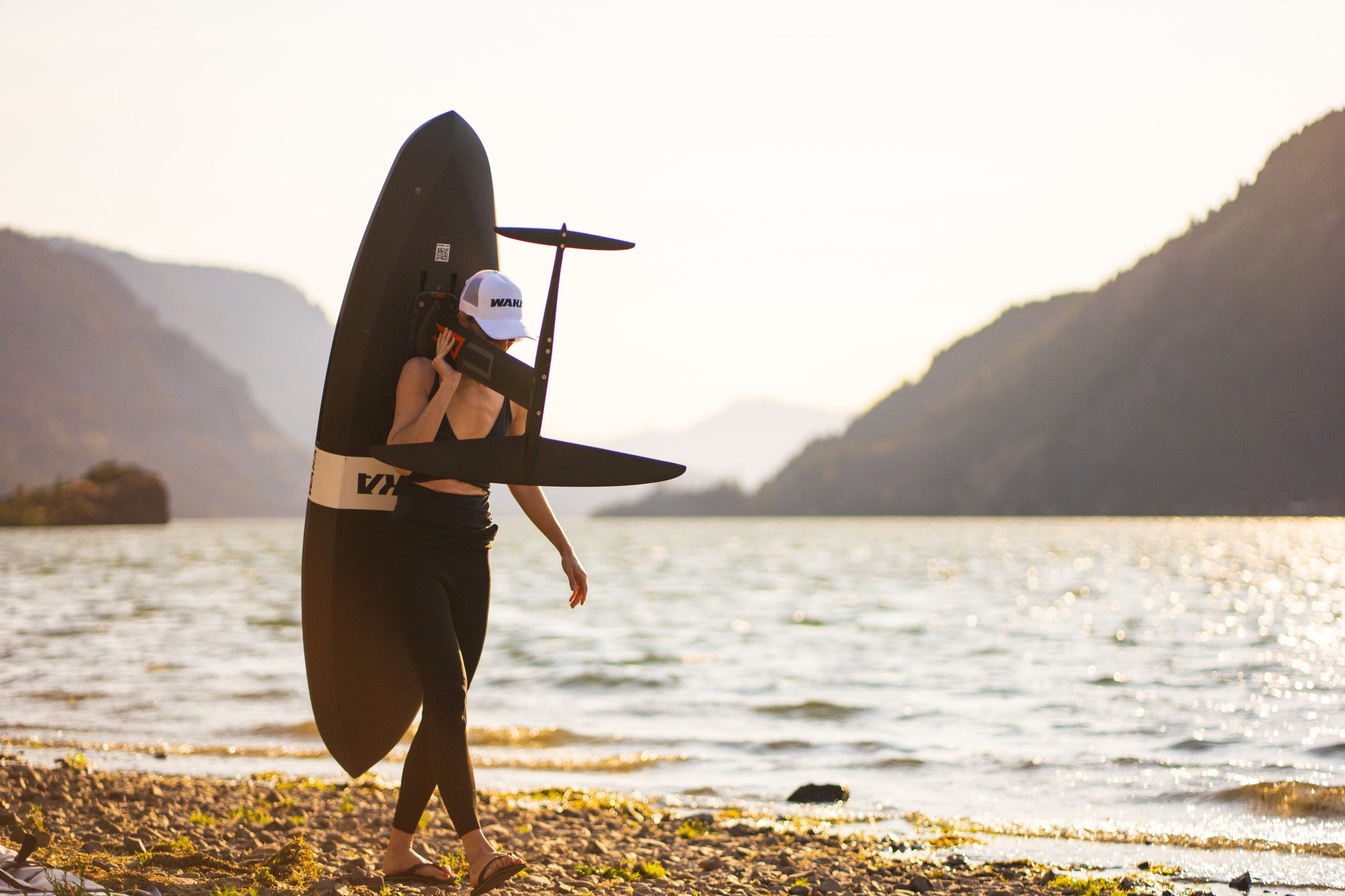 Carrying a WAKA board and foil along the shoreline