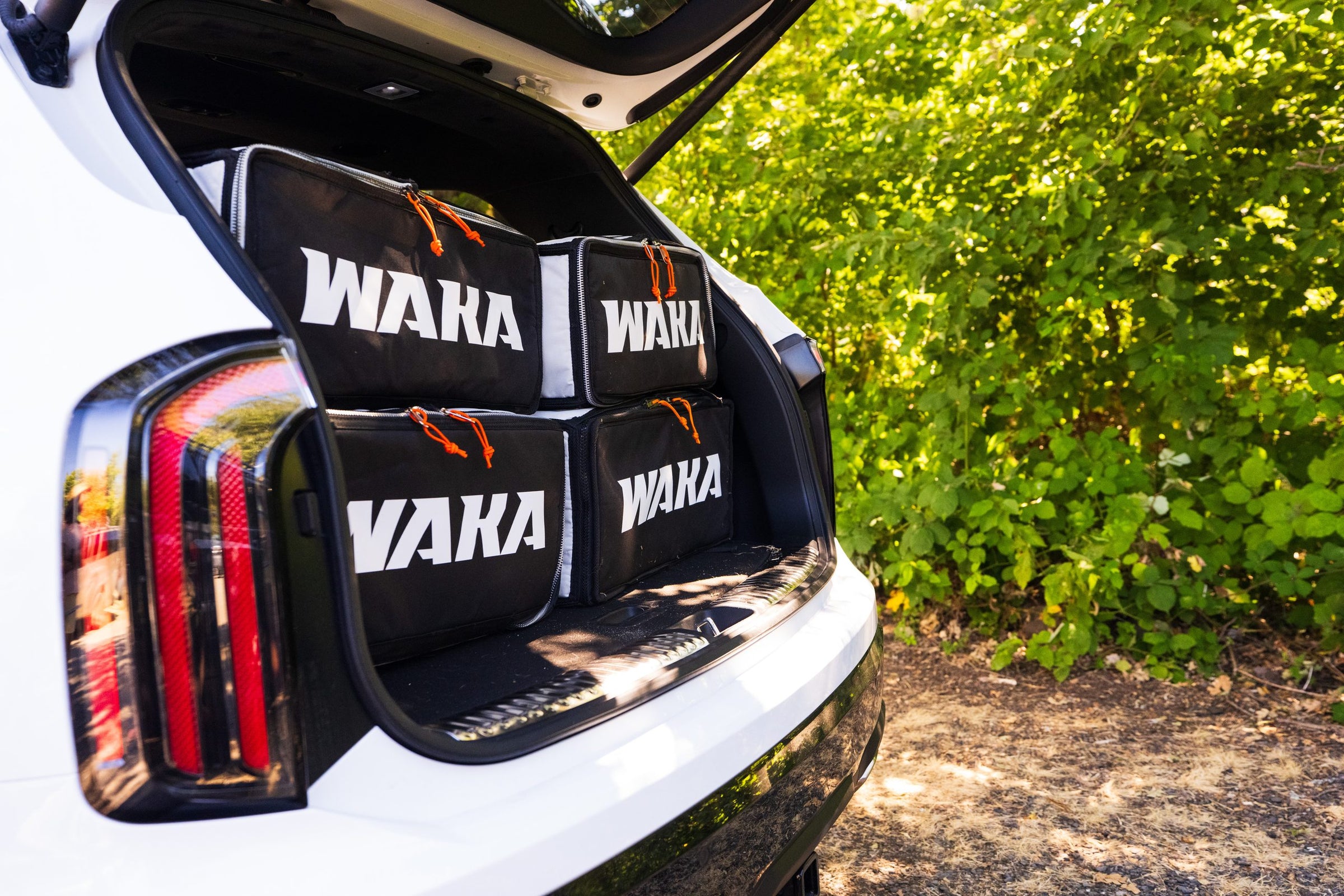 Four WAKA board bags loaded in a car boot